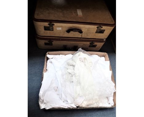 A COLLECTION OF VINTAGE LINENS including a Christening gown, with a pair of mid 20th century suitcases with brown leather tri