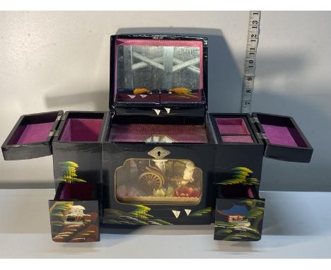 A vintage Japanese lacquered and hand decorated musical jewellery box with moving internal display 
