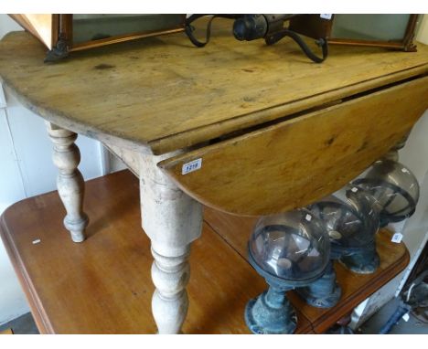 A large pine bow-end kitchen table, on baluster legs, length 130cm