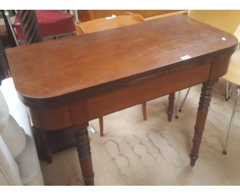 A 19th century mahogany fold over card table, raised on turned legs, width 92cm