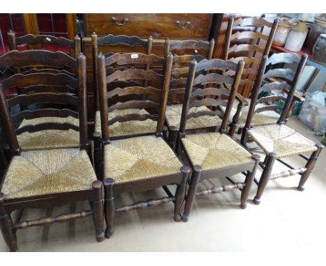 A harlequin set of 8 oak and ask ladder back dining chairs, with rush seats 