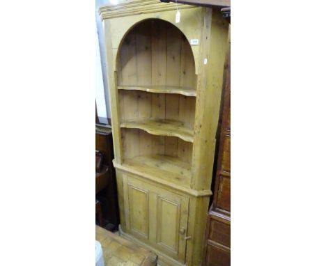 A polished pine bow-back corner cabinet, with open shelves above a panelled cupboard, width 87cm