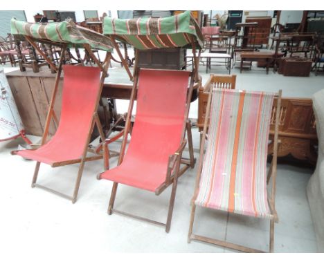 Three vintage deckchairs, including two with canopies