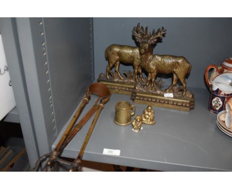 Two brass door stops in the shape of deer, a copper and brass fork and tongs, and three whimsical ornaments, including a rath