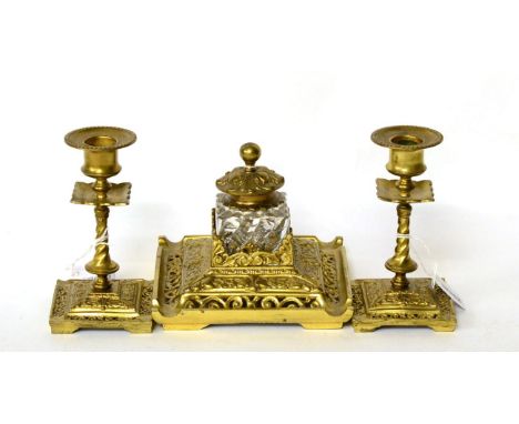 A three piece gilt brass desk set comprising inkwell with a pair of candlesticks (3)  