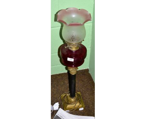 A Victorian brass lamp with ruby glass reservoir 