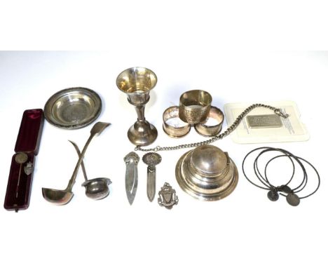 A group of assorted silver items to include: five commemorative silver 1oz ingots; a capstan inkwell; two sauce ladles; napki