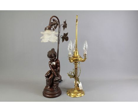 A Composite Table Lamp. The lamp depicting a seated cherub supported on a stem of leaves with an opaque floral shade, approx 