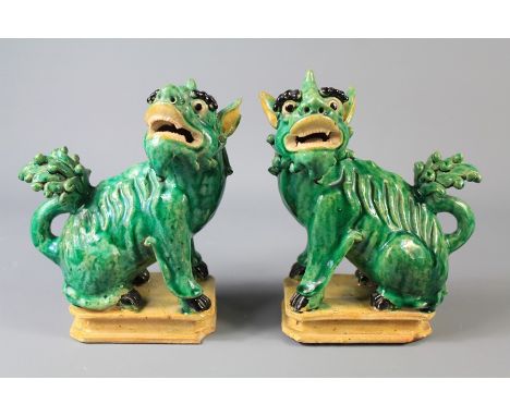 A Pair of Antique Emerald-Green Ceramic Kylins. The figures depicted seated and raised on a square plinth, approx 18 cms