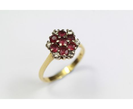 A Vintage 18ct Gold Ruby and Diamond Cluster Ring. The ring set with 7 x 3mm rubies and 6 x 2 pts of dias, size O, approx 4 g