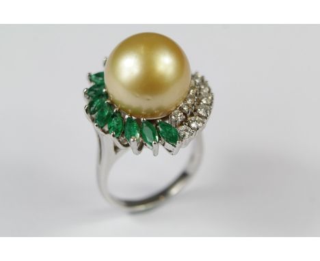 A 18ct White Gold South Sea Pearl and Emerald Dress Ring. The central pearl approx 13.8 x 13.7mm set with eleven marquise-cut