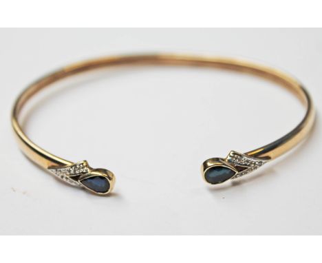 A 9ct gold diamond and black stone bangle, diam. 6.5cm, gross wt. 5.8g.