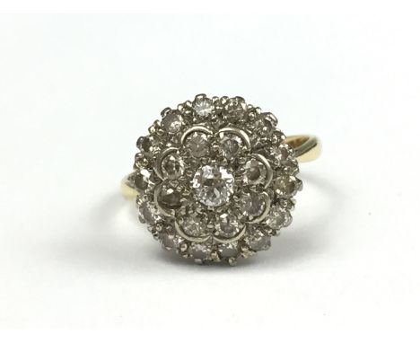 A vintage diamond flower head cluster ring, comprising two tiers of pellet-set brilliant-cut diamonds, surrounding a central 