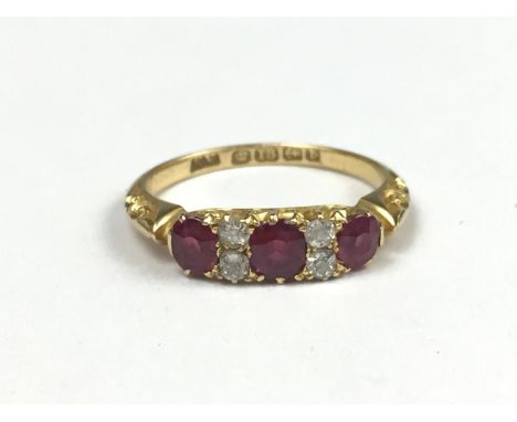 An Edwardian ruby and diamond ring, comprising three oval-cut rubies divided by pairs of diamond brilliants, approximately 1 