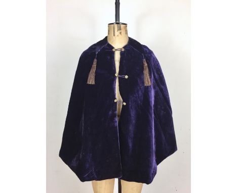 A late Victorian amethyst crushed velvet evening cape, having a pointed collar terminating in tassels, and gilt buttons, circ