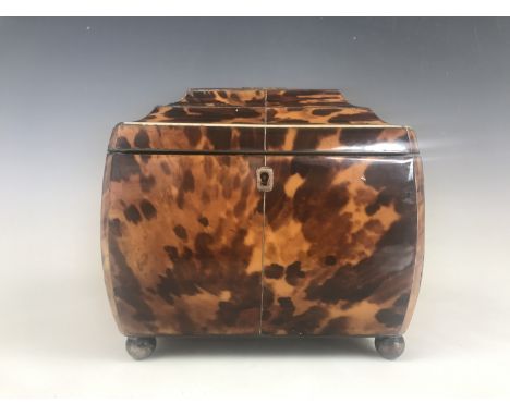 A Georgian tortoiseshell tea caddy, of bombe form, having white-metal and ivory string inlay, a vacant white-metal cartouche,