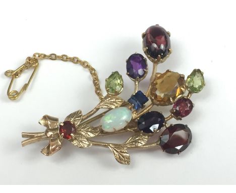 A modern 9ct gold gemstone specimen brooch modelled as a ribbon-tied bouquet of blossoms, the 'flowers' comprising various ca