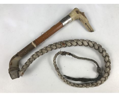 A late 19th Century antler handled riding whip, the handle naively carved as the head of a whippet, and incorporating a pea w