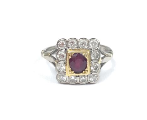 A ruby and diamond ring, comprising a central oval cut ruby of approximately .5 ct, millegrain set within a rectangular yello