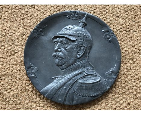 A large early 20th Century German Britannia metal plaque bearing a relief portrait of Otto von Bismark, 47 cm