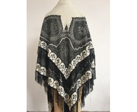 A Victorian embroidered cream wool shawl, having black chain-stitched boteh decoration, applied in such a way as to ensure th