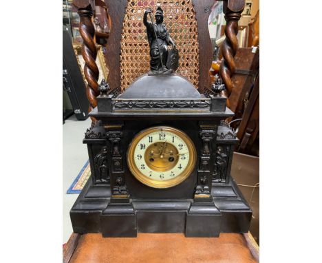 A Victorian slate mantel clock designed with metal trims, figures and Britannia figurine to the top. Face is made from white 