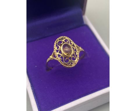 An Import London 9ct gold ladies ring in an Art Nouveau Form. Designed with a single oval cut pale yellow stone. Ring size Q.