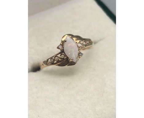 A Ladies 9ct gold ring set with a single opal stone off set by two single diamonds. Ring size 0. 