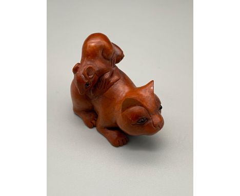 A Hand carved Japanese netsuke of a mouse on top of a cat. Signed by the artist. [5cm length] 