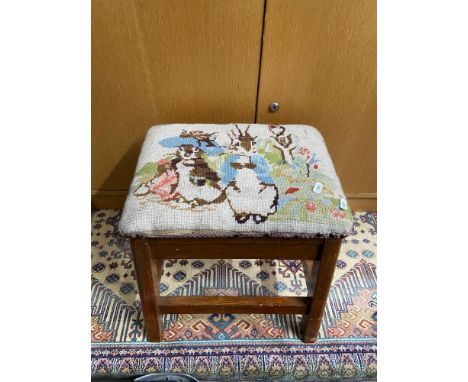 A Vintage footstool, designed with a tapestry of Peter Rabbit. [38cm height]