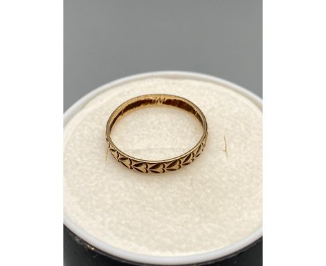 A Ladies 9ct gold wedding band designed with engraved hearts. Ring size M1/2.[1.25 Grams] 