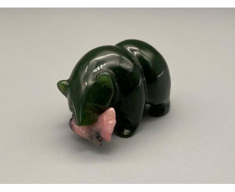 A Chinese green jade carved bear holding a pink fish within its mouth. [4cm length] 