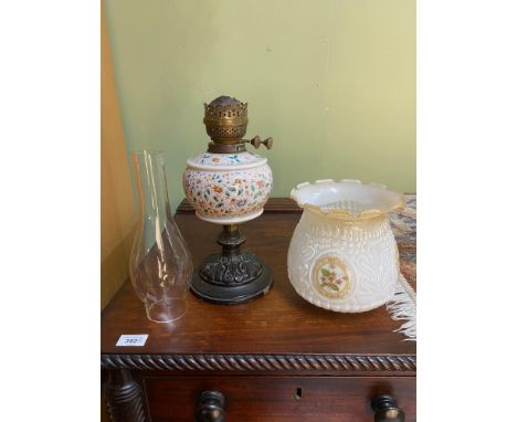A Victorian paraffin desk lamp. Designed with a ceramic ornate base, Bulbous hand painted glass body in the style of Moser an