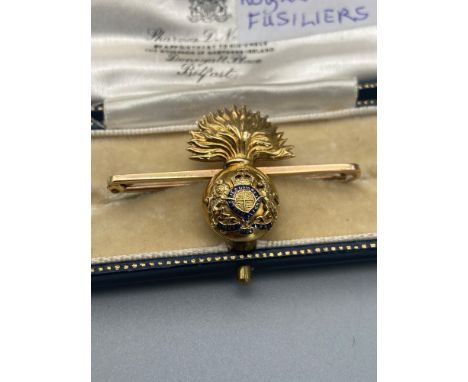 A 16ct gold and enamel Royal Fusiliers bar brooch. [5.91grams] 