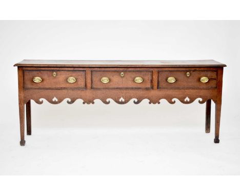 An 18th Century oak and mahogany crossbanded dresser base, probably West Midlands, the rectangular moulded top above three co
