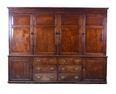 A large George III oak housekeeper's cupboardThe narrow ogee cornice above a plain frieze and four cupboard doors with fielde