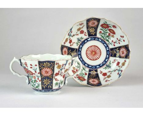 A Worcester twin-handled chocolate cup and stand, circa 1775, the ogee cup and saucer decorated in a kakiemon Japan pattern, 