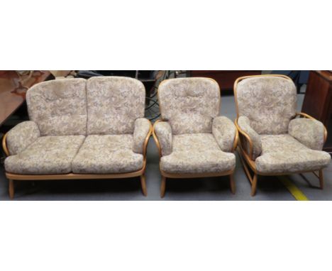 An Ercol two seater sofa, along with two single Ercol armchairs 