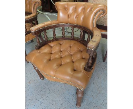 A button back captain's chair with a mahogany frame & tan leather upholstery 