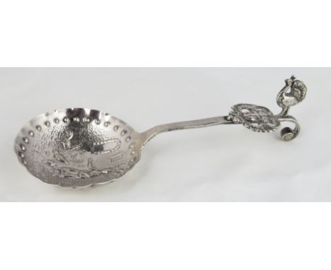 A continental spoon, with embossed bowl of a woman feeding chickens, the short stem with a peacock finial, 12.5 cm long