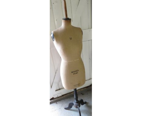A Levine female mannequin on a black tripod base, along with a stocking leg 