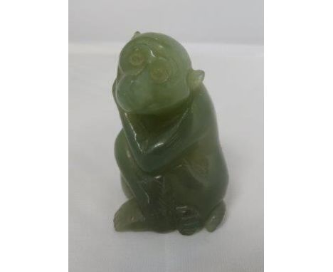 A Chinese hardstone carving of a seated monkey, possibly jade, 5cm high