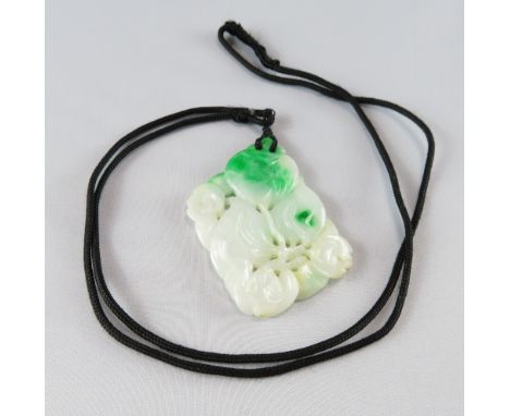 A jade pendant, carved as peaches &amp; foliage, approximately 5.4 cm by 4.2 cm, on a cord