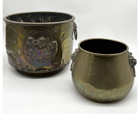 An Arts and Crafts style brass planter/coal bucket with lion's head handles along with another smaller example