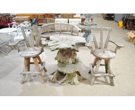 A rustic garden table formed from a tree trunk with a pair of weathered oversized wooden swivel chairs - height of table 95cm