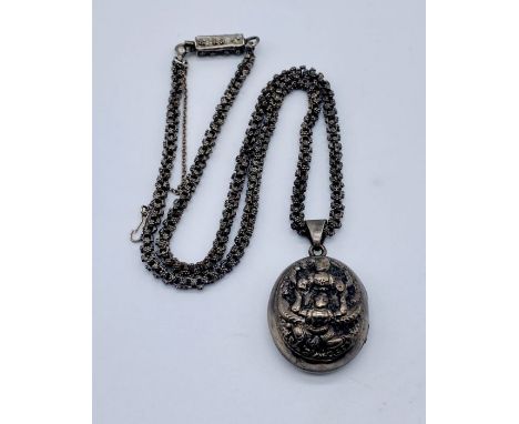 An Indian silver locket depicting Deities on fancy silver chain