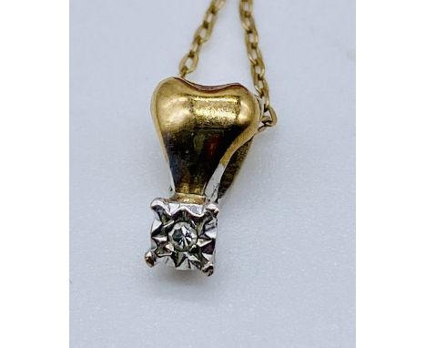 A diamond pendant set in gold on a 9ct gold fine chain
