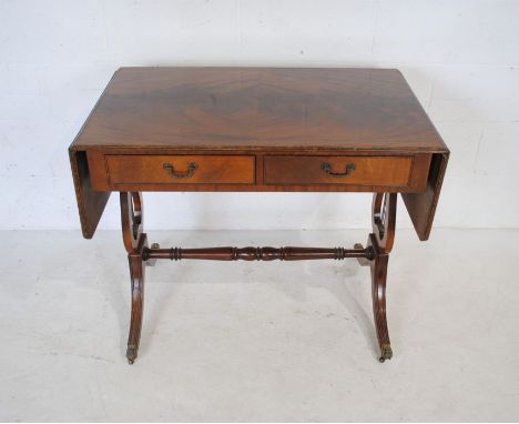 A reproduction mahogany sofa table with two drawers and lyre supports 