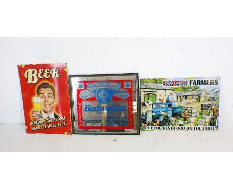 A framed Budweiser advertising mirror 65cm x 57cm, plus two retro enamel signs for beer and British Farmers.