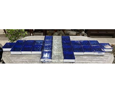 A collection of retro glass tiles. Twenty two blue tiles, four clear tiles. Each tile is double sided, 19cm x 19cm with a dep